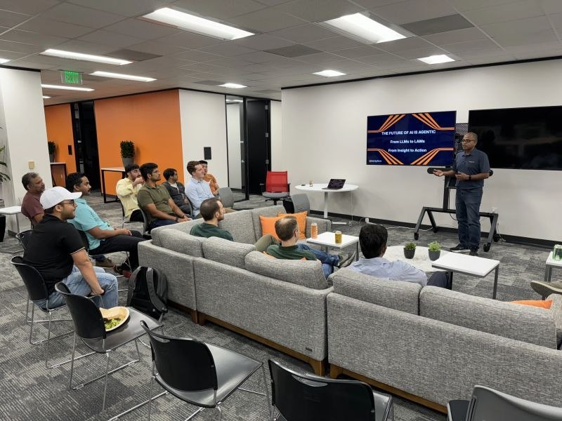 Attendees seated on sofas listening to a speaker at a developer meetup in Austin.