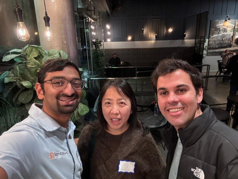 Three people taking a selfie together at a casual indoor meetup.