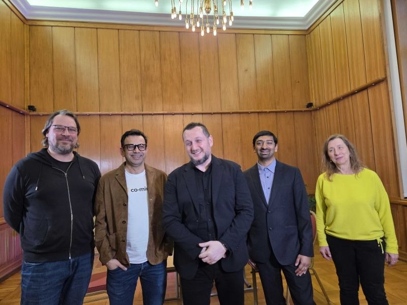 Five attendees posing together in a wood-paneled room at SambaHouse in Germany.